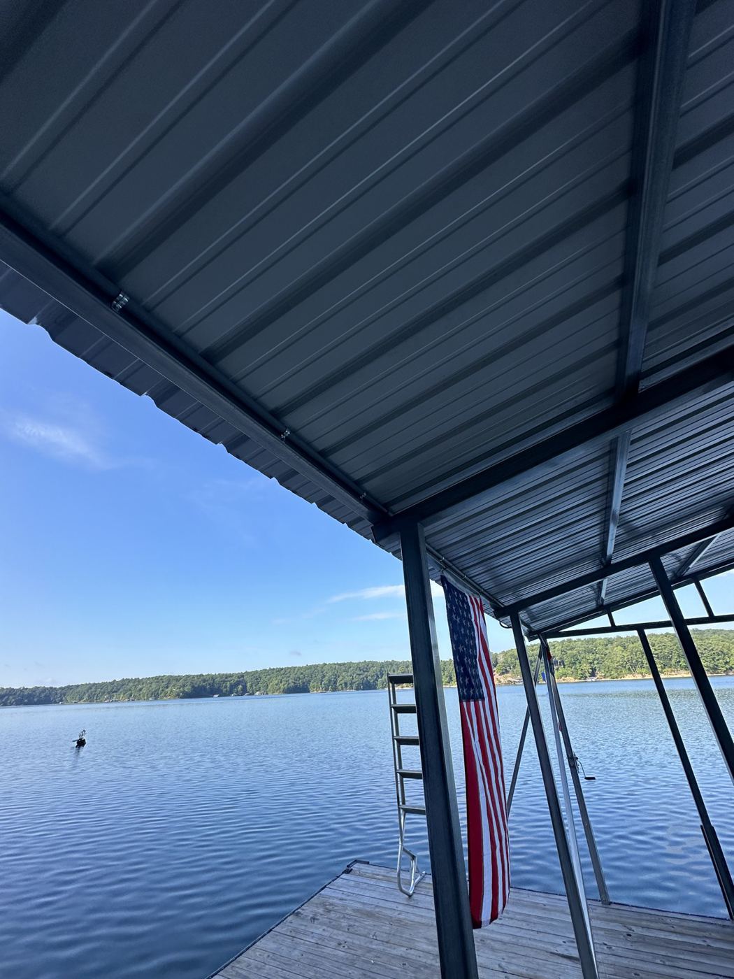 View of Smith Lake from under a covered dock canopy with an American flag